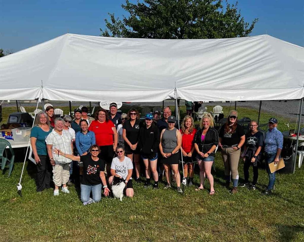 large group of volunteers in front of tent