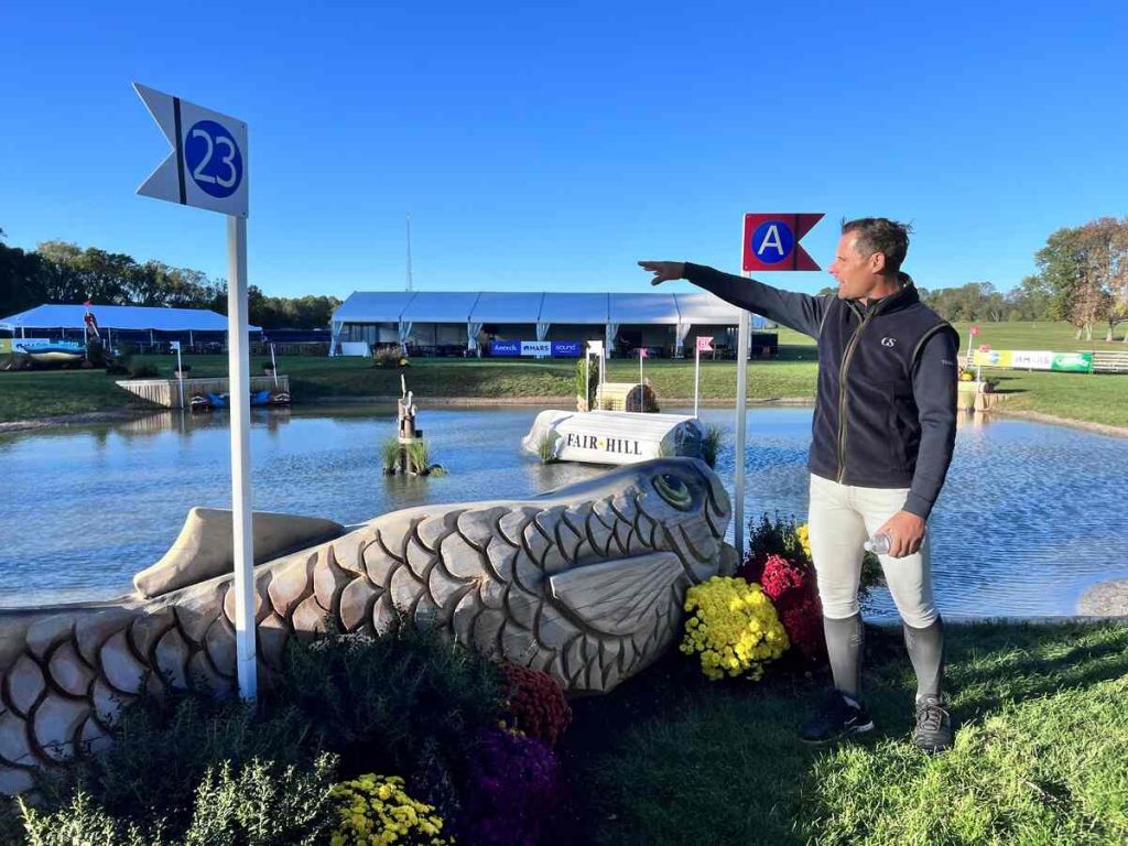 Man pointing over cross country jump