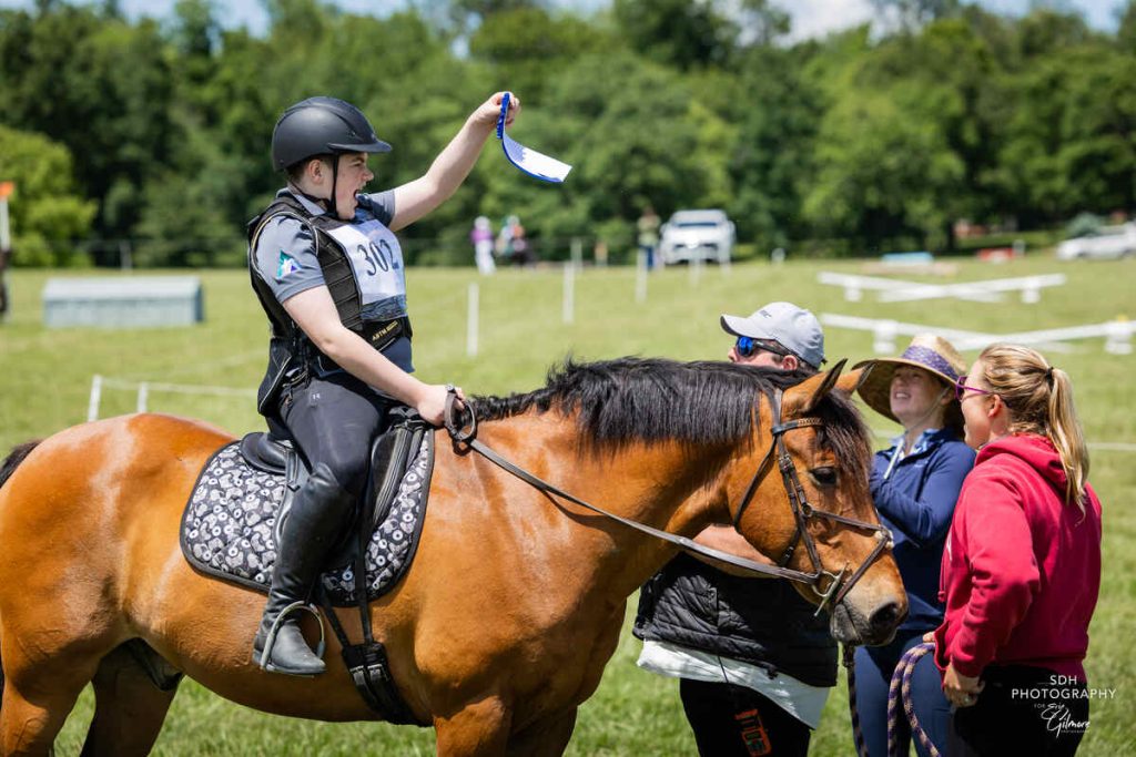 Rider on horse waving ribbon