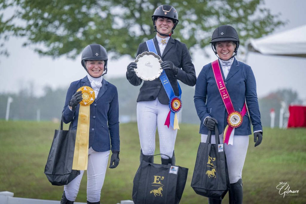 Three riders on podium with awards.